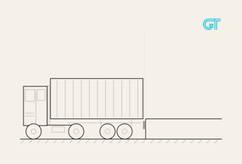 A tractor trailer backing into a loading dock.